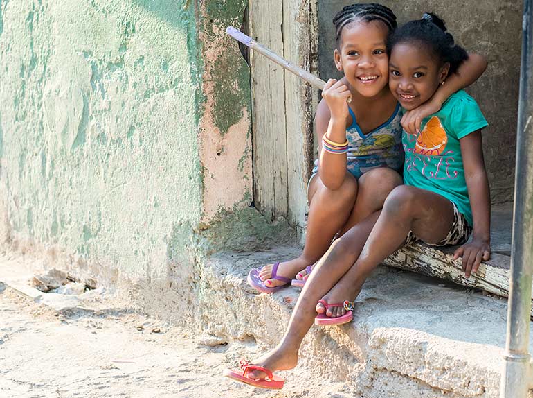 Two Cuban girls play on the street after school.