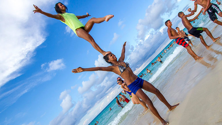 Cuban female acrobats on beach.