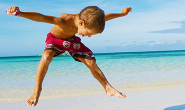 American boy playing on Cuba beach.